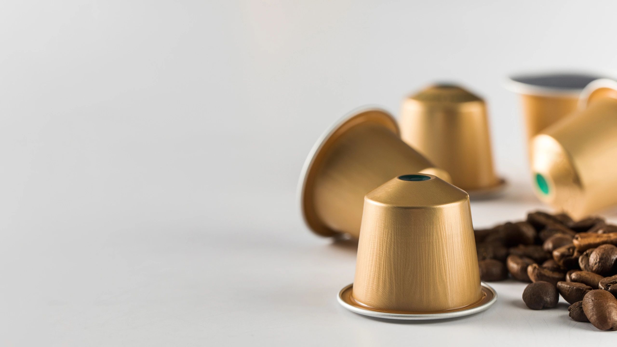 Coffee capsules with coffee beans on a light background