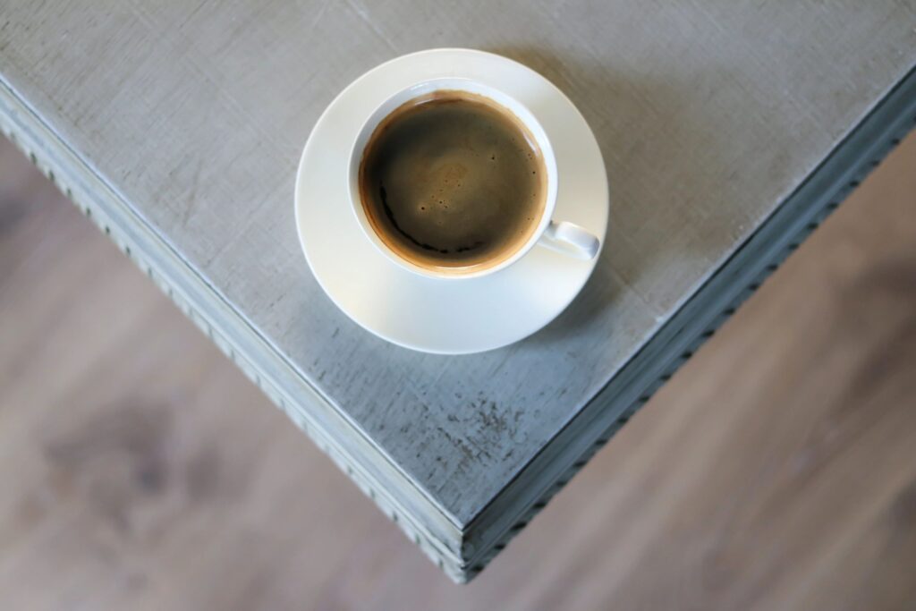 Cup of coffee on a saucer sitting on a wooden table